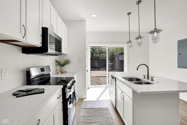 kitchen with stainless steel appliances, a sink, light wood-type flooring, and light countertops