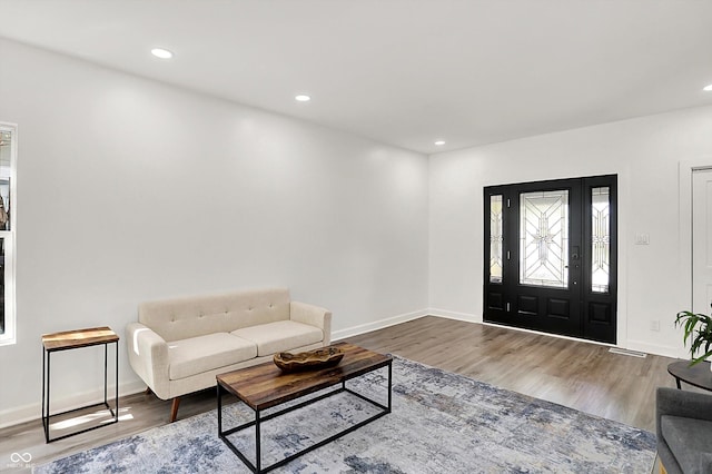 living room with wood finished floors, baseboards, and recessed lighting