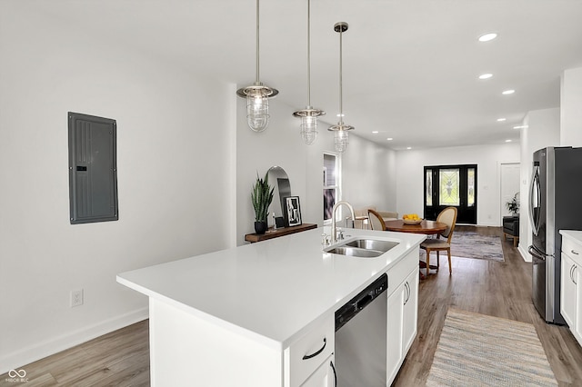 kitchen with a sink, stainless steel appliances, electric panel, light wood-style floors, and recessed lighting