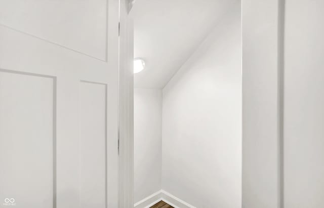 additional living space with baseboards and wood finished floors