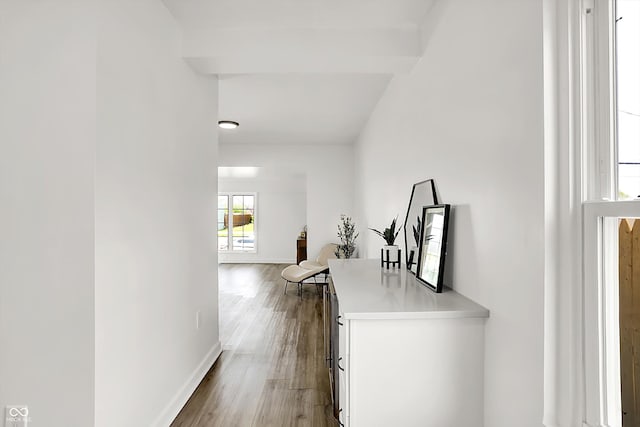 corridor featuring baseboards and wood finished floors