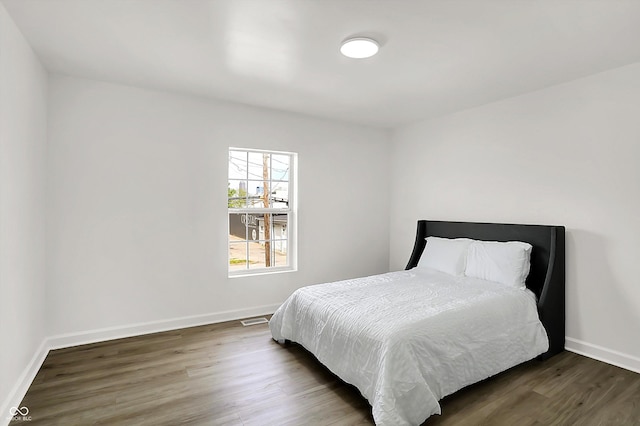 bedroom featuring wood finished floors and baseboards