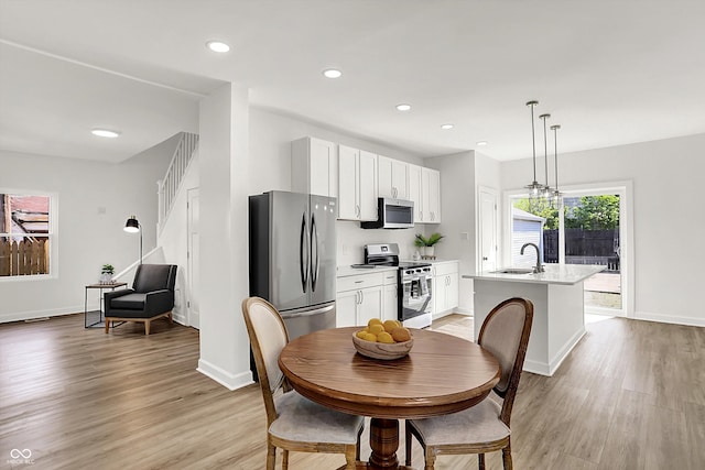dining space with light wood finished floors, baseboards, and recessed lighting