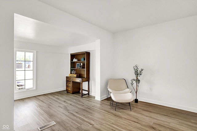 sitting room with light wood-type flooring and baseboards