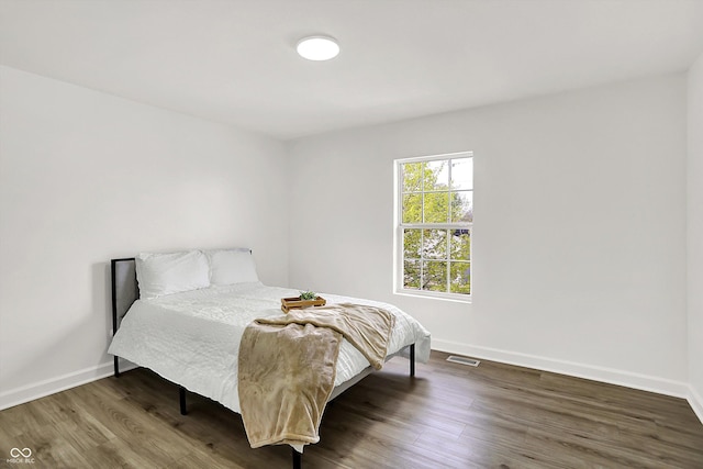 bedroom featuring baseboards and wood finished floors