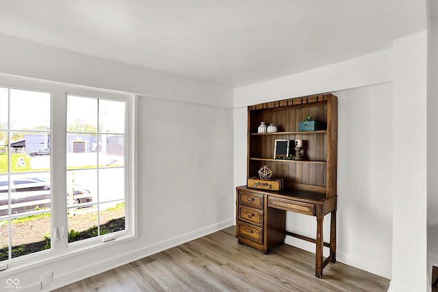 office space with light wood-style floors and baseboards