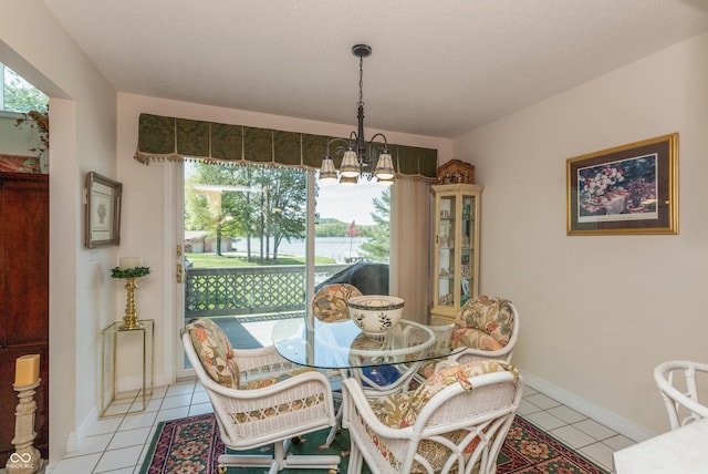 889 E N Shore Dr, Brownstown, IN 47220 - dining area featuring a chandelier, light tile patterned flooring, a water view, and baseboards