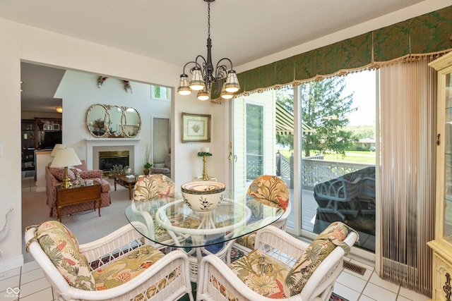 889 E N Shore Dr, Brownstown, IN 47220 - dining space with a chandelier, tile patterned flooring, and a glass covered fireplace