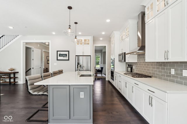 9155 Kerwood Dr, Indianapolis, IN 46240 - kitchen with stainless steel appliances, a sink, wall chimney exhaust hood, a kitchen bar, and tasteful backsplash