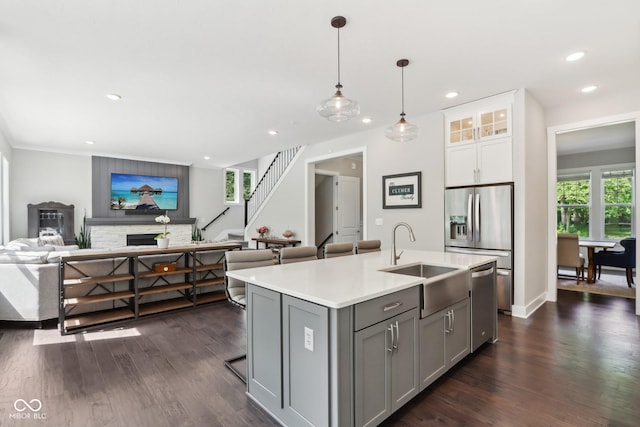 9155 Kerwood Dr, Indianapolis, IN 46240 - kitchen featuring a sink, gray cabinets, appliances with stainless steel finishes, open floor plan, and a fireplace