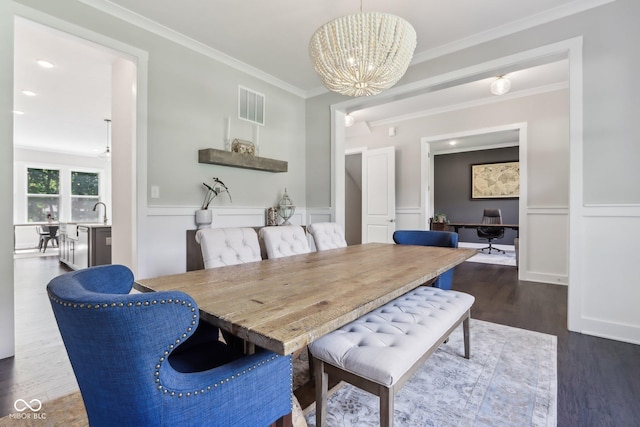 9155 Kerwood Dr, Indianapolis, IN 46240 - dining room with a chandelier, dark wood-type flooring, crown molding, a wainscoted wall, and a decorative wall