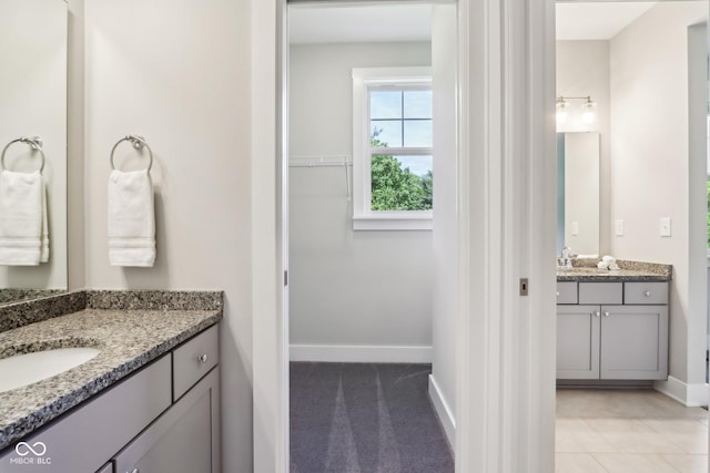 9155 Kerwood Dr, Indianapolis, IN 46240 - bathroom with two vanities, a spacious closet, and baseboards