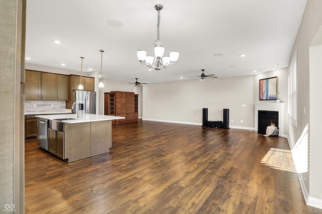6153 Dugan Dr, Whitestown, IN 46075 - kitchen featuring a ceiling fan, a warm lit fireplace, open floor plan, appliances with stainless steel finishes, and a chandelier