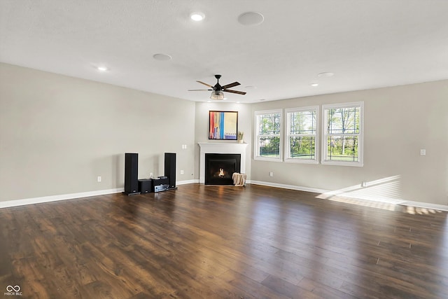 6153 Dugan Dr, Whitestown, IN 46075 - unfurnished living room with ceiling fan, dark wood-style floors, a lit fireplace, baseboards, and recessed lighting