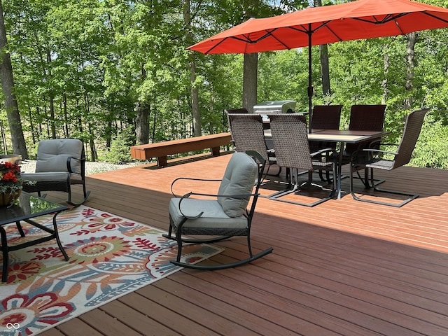 wooden terrace featuring outdoor dining space and grilling area