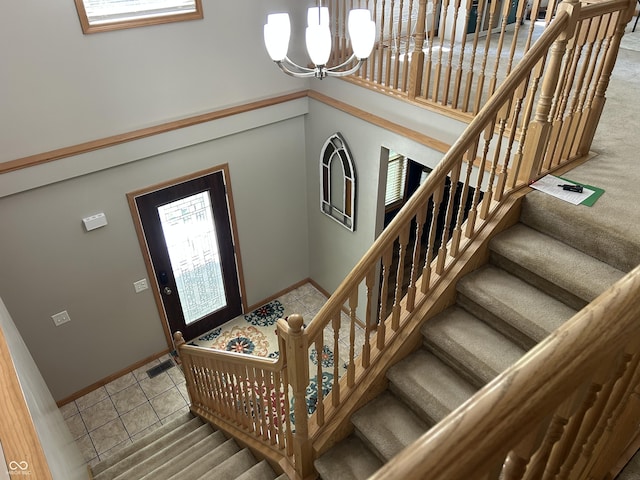 stairs featuring a chandelier, baseboards, and tile patterned floors