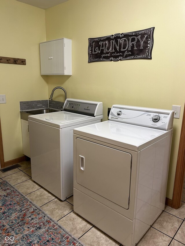 washroom with separate washer and dryer, cabinet space, light tile patterned flooring, and baseboards