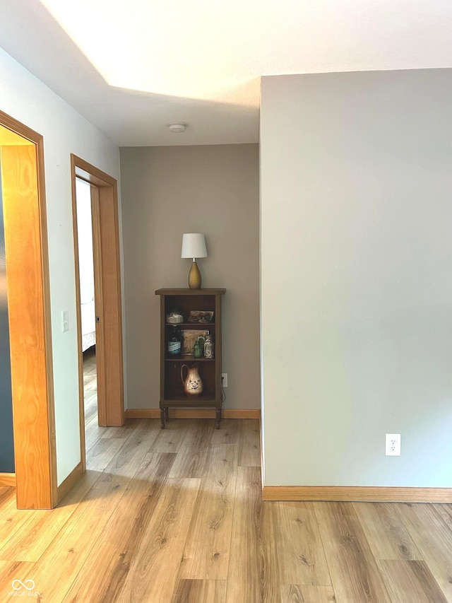 hallway featuring wood finished floors and baseboards