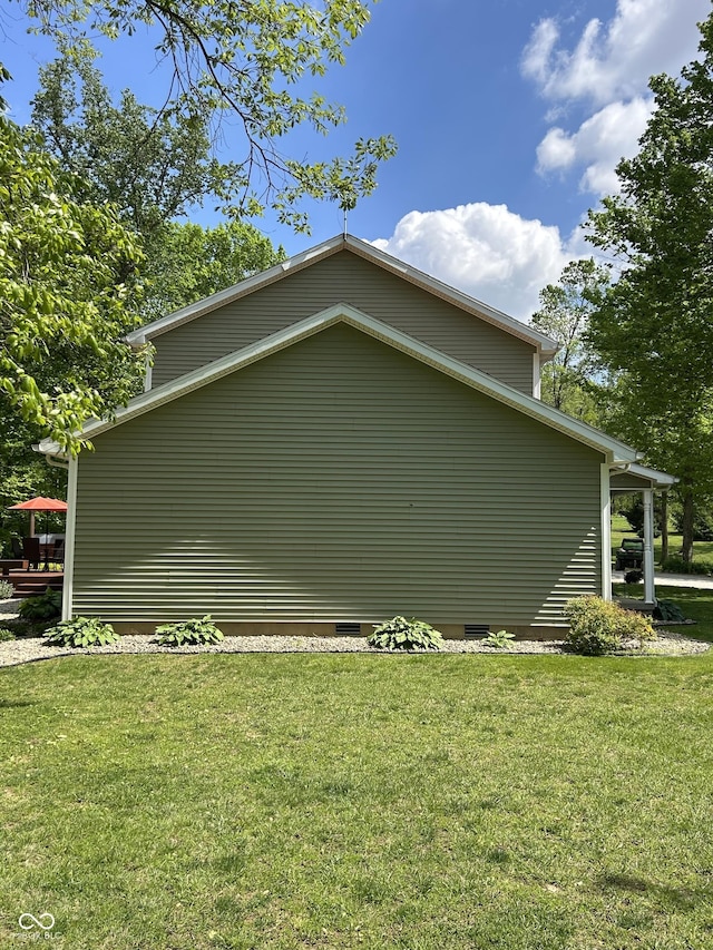 view of side of home with a lawn and crawl space