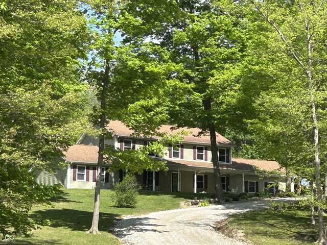 view of front of house with a front lawn and gravel driveway