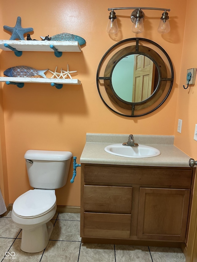 half bath with vanity, toilet, tile patterned floors, and baseboards