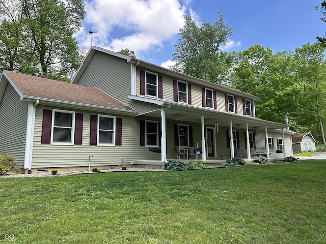 colonial inspired home with a porch, a front yard, an outbuilding, and a storage unit