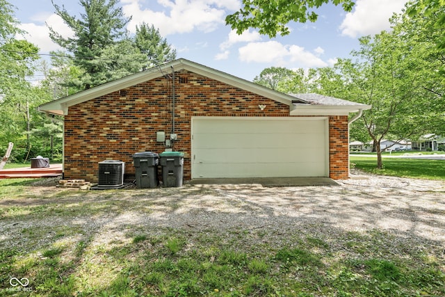 view of side of property with brick siding, central AC unit, and an attached garage