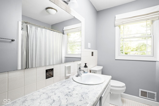 bathroom with toilet, vanity, baseboards, and a shower with curtain