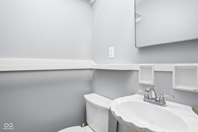 half bathroom with a sink and toilet