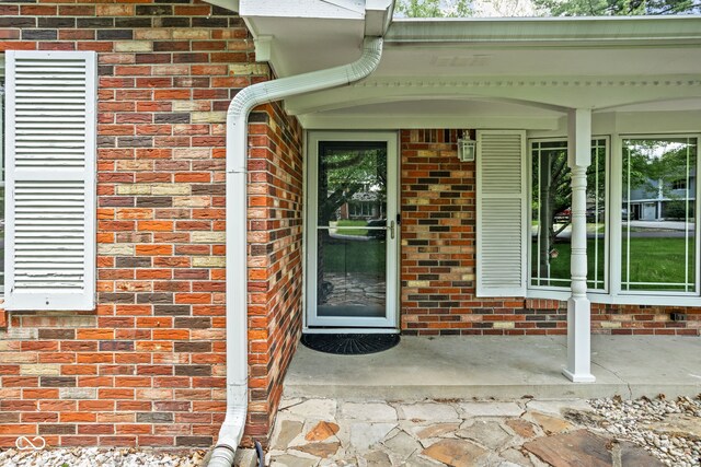 view of exterior entry featuring brick siding