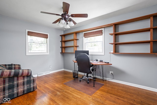 office area featuring healthy amount of natural light, baseboards, wood finished floors, and ceiling fan