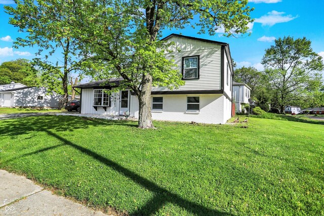 view of front of home with a front yard and brick siding