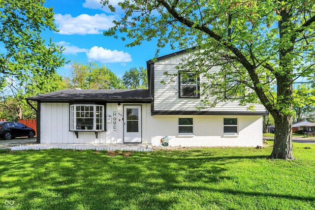 split level home with brick siding and a front lawn