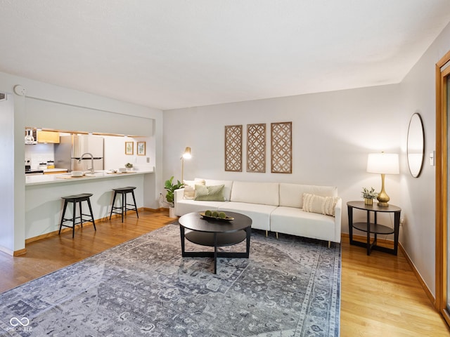 living room with light wood-type flooring and baseboards
