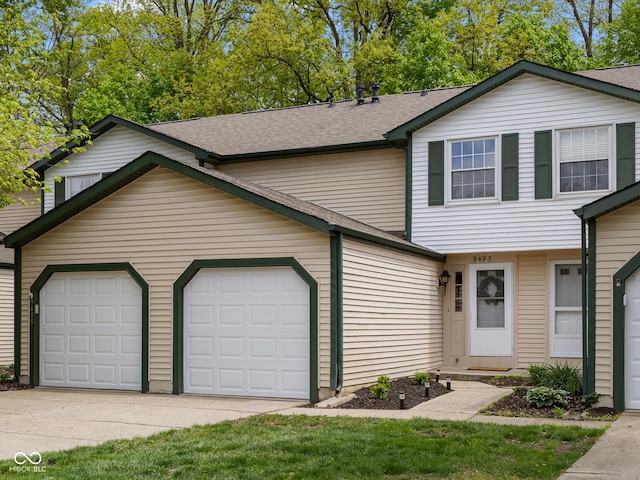 multi unit property featuring a garage, driveway, and a shingled roof