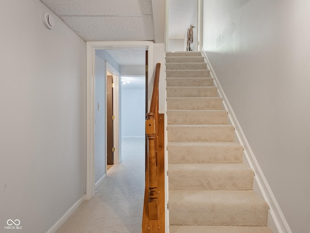 stairway featuring carpet floors and baseboards