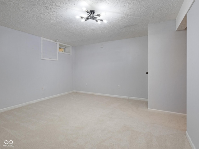unfurnished room featuring light carpet, a textured ceiling, and baseboards