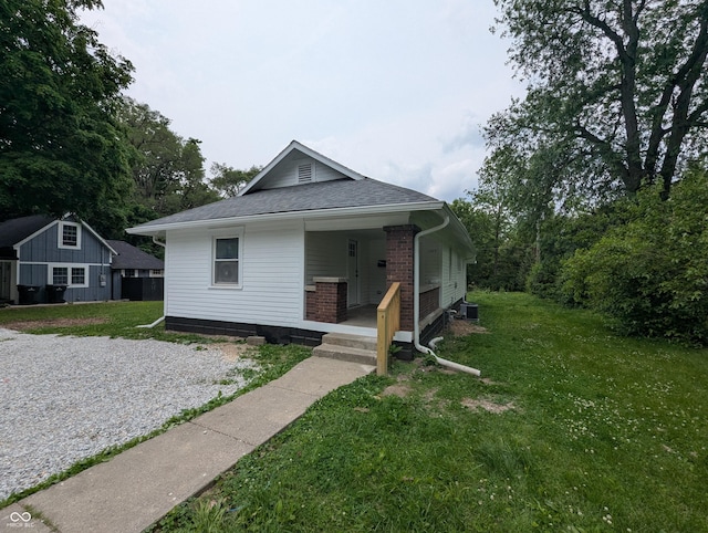 1009 Chestnut St, Anderson, IN 46012 - bungalow-style home featuring covered porch, a front yard, and a shingled roof