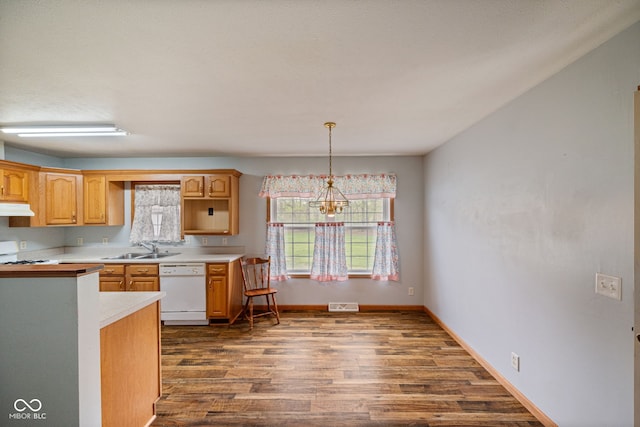 kitchen with dishwasher, under cabinet range hood, a sink, dark wood finished floors, and light countertops