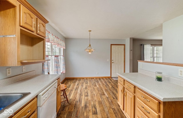 kitchen with dishwasher, a sink, plenty of natural light, and wood finished floors