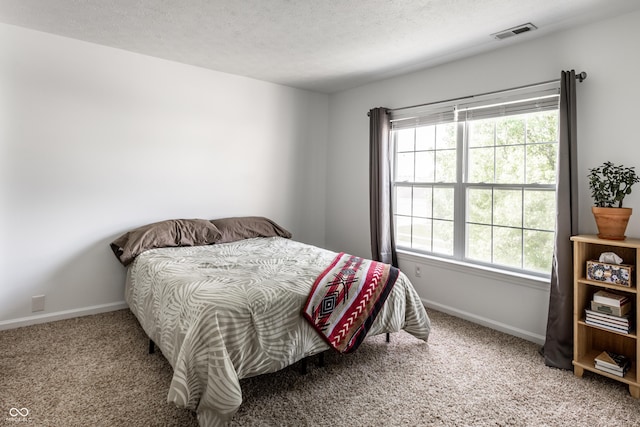 carpeted bedroom with baseboards, multiple windows, and a textured ceiling