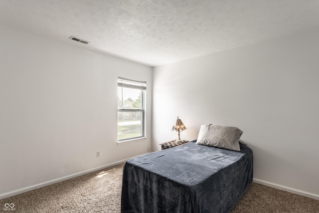 bedroom featuring carpet, baseboards, and a textured ceiling