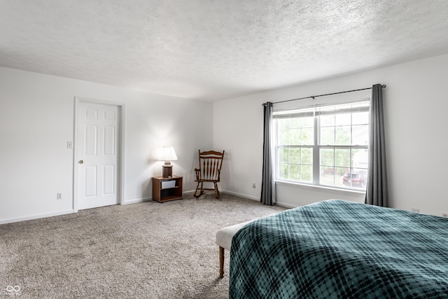 bedroom with a textured ceiling, carpet flooring, and baseboards