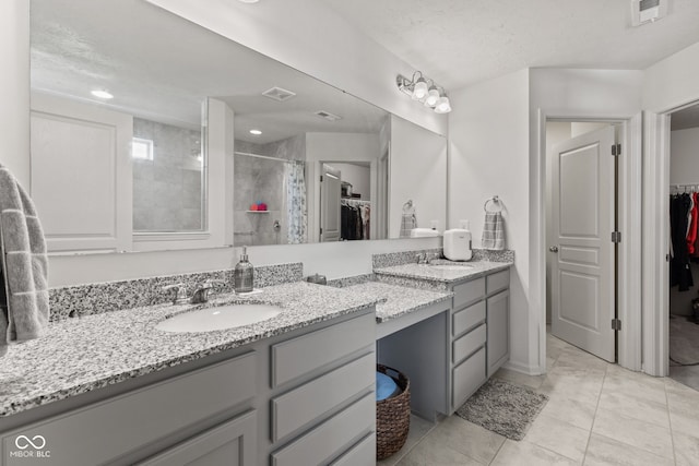 1289 Sunset Blvd, Avon, IN 46123 - bathroom with tiled shower, a spacious closet, vanity, and tile patterned flooring