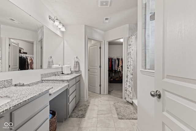 1289 Sunset Blvd, Avon, IN 46123 - bathroom featuring a tile shower, double vanity, and tile patterned flooring