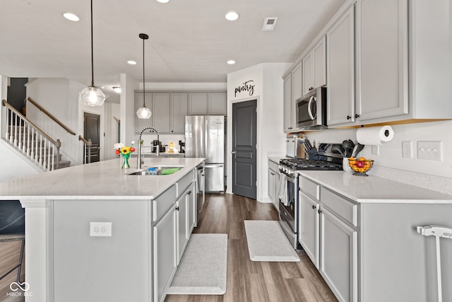 1289 Sunset Blvd, Avon, IN 46123 - kitchen featuring appliances with stainless steel finishes, a sink, dark wood-style floors, a kitchen breakfast bar, and an island with sink