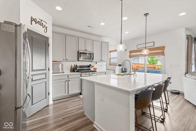 1289 Sunset Blvd, Avon, IN 46123 - kitchen featuring stainless steel appliances, a sink, light wood finished floors, recessed lighting, and a kitchen bar