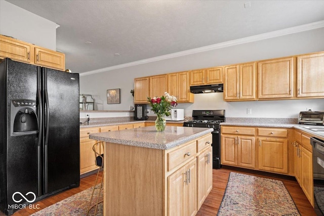 2405 N Park Ave, Indianapolis, IN 46205 - kitchen with black appliances, under cabinet range hood, ornamental molding, a center island, and wood finished floors