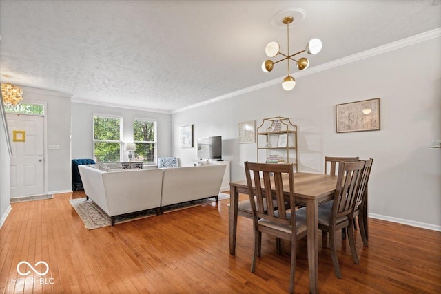 2405 N Park Ave, Indianapolis, IN 46205 - dining room featuring a chandelier, ornamental molding, light wood-style flooring, baseboards, and a textured ceiling