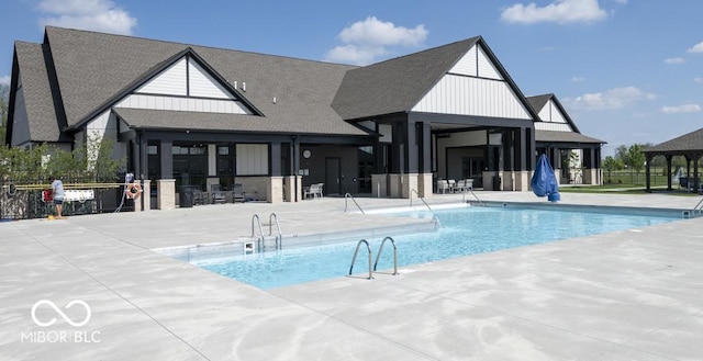 community pool with a patio area and fence